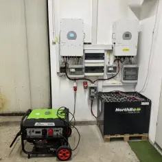 System magazynowania energii do domu: dwa falowniki, skrzynka z bezpiecznikami, agregat prądotwórczy i duży akumulator NorthBaH.