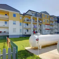 Zbiorniki gazu LPG przy bloku mieszkalnym. Zastanawiasz się nad ogrzewaniem gazowym koszty? Oto rozwiązanie.