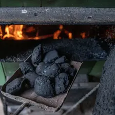 Łopata z węglem przed piecem. Wiele osób zastanawia się, do kiedy wymiana pieca na wsi, by ogrzewać dom ekologicznie.